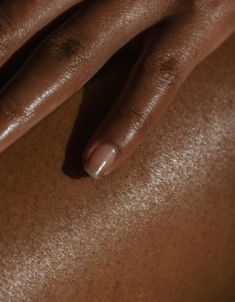 Crop ethnic person touching bare skin